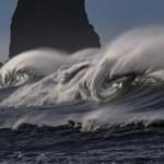 Jättimainen aalto kivisellä merenrannalla. 